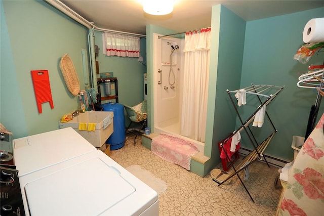 interior space featuring washing machine and clothes dryer, curtained shower, and sink