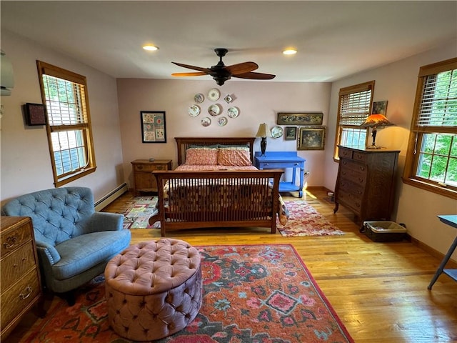 bedroom featuring multiple windows, ceiling fan, a baseboard radiator, and light hardwood / wood-style floors