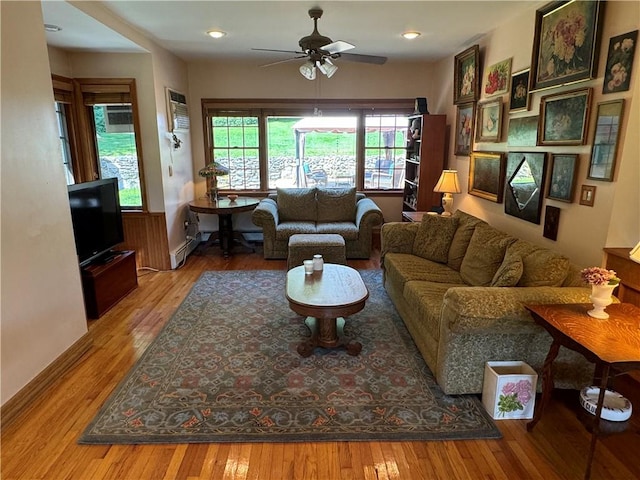 living room with wood-type flooring, a wealth of natural light, and ceiling fan