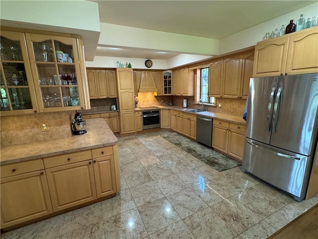 kitchen with appliances with stainless steel finishes, backsplash, light brown cabinets, and sink