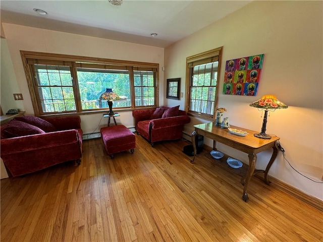 sitting room featuring plenty of natural light, light wood-type flooring, and a baseboard radiator