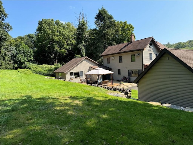 back of house with a lawn, a wooden deck, and a gazebo