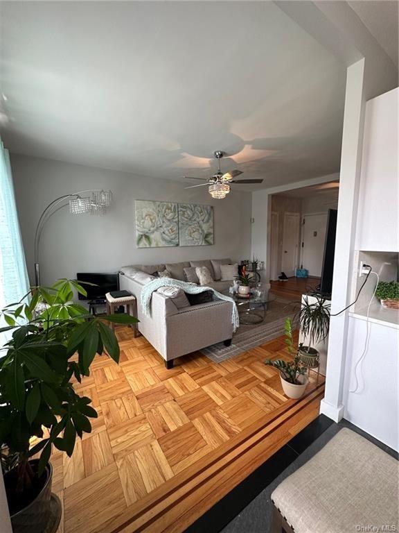 living room featuring ceiling fan and light parquet flooring