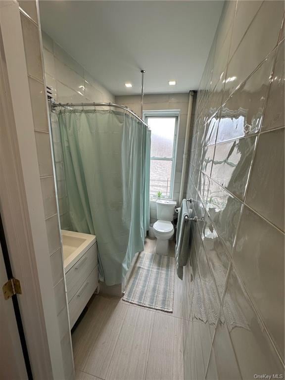 bathroom featuring a shower with shower curtain, hardwood / wood-style floors, vanity, and toilet