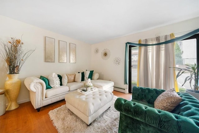 living room with baseboard heating, plenty of natural light, and hardwood / wood-style floors