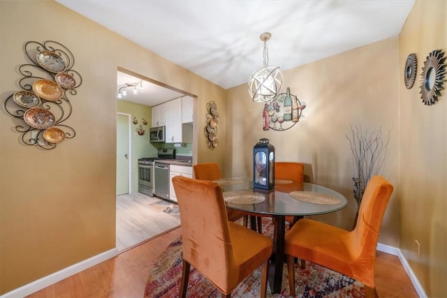 dining space featuring a chandelier and light wood-type flooring