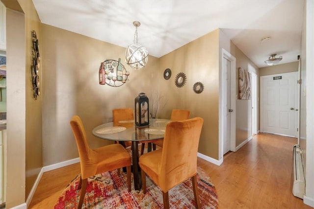 dining room with light hardwood / wood-style flooring and an inviting chandelier