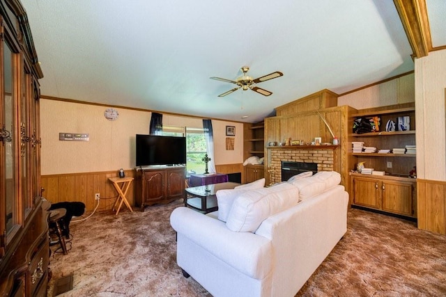 living room featuring carpet, lofted ceiling, ceiling fan, ornamental molding, and a fireplace