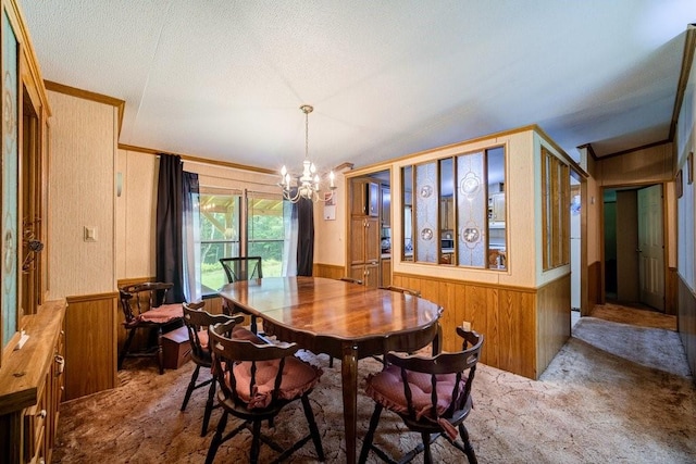 carpeted dining area with wood walls, a chandelier, and a textured ceiling