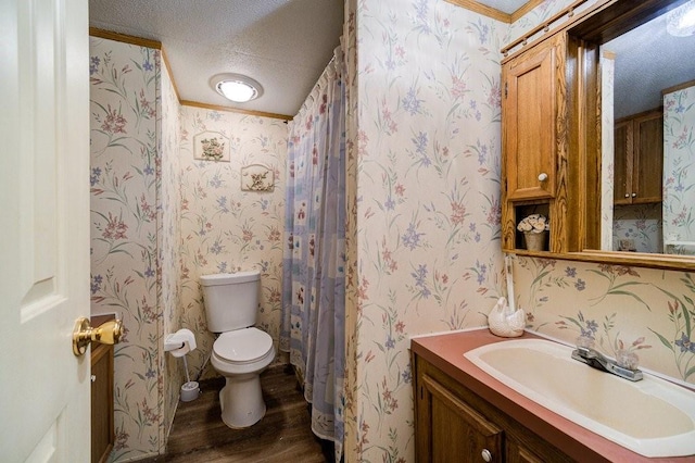 bathroom with vanity, a textured ceiling, crown molding, wood-type flooring, and toilet