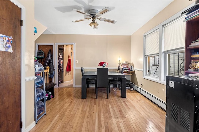 dining space with baseboard heating, ceiling fan, and light hardwood / wood-style floors