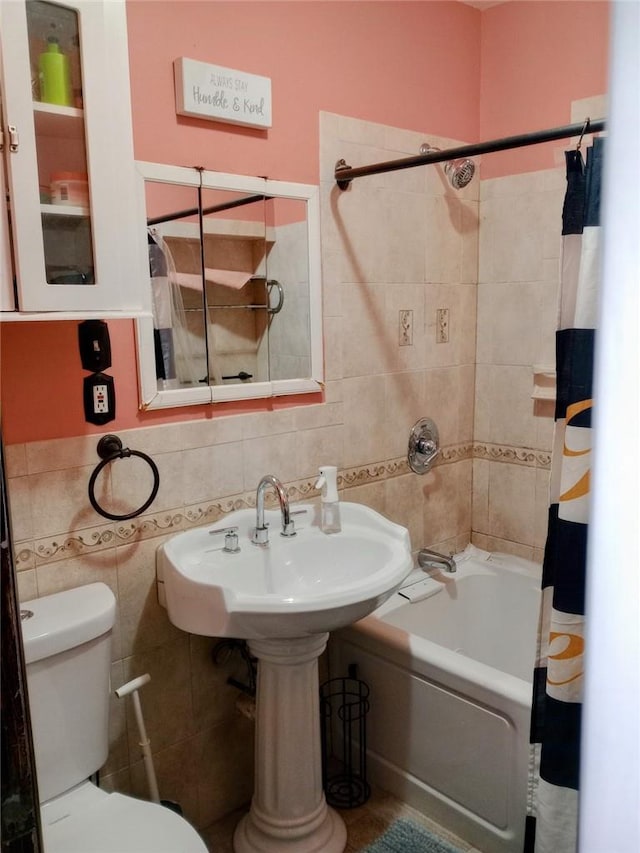 full bathroom featuring sink, toilet, shower / bath combo with shower curtain, and tile walls