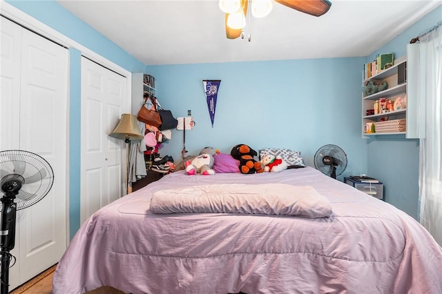 bedroom with ceiling fan and multiple closets