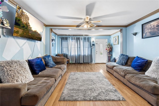 living room featuring light hardwood / wood-style floors, ceiling fan, and ornamental molding