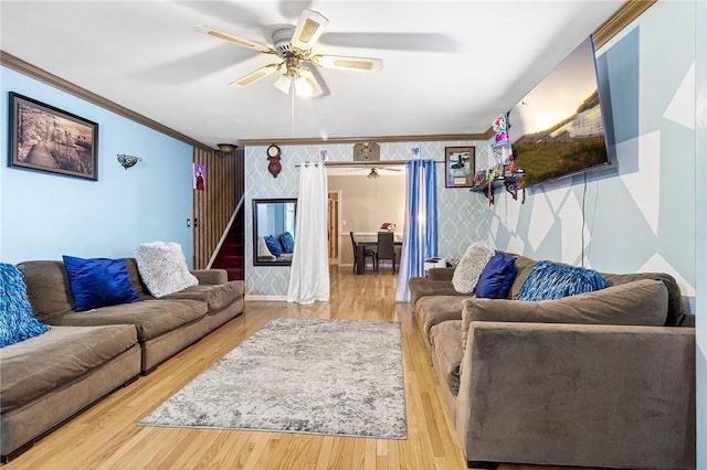 living room with hardwood / wood-style flooring, ceiling fan, and crown molding