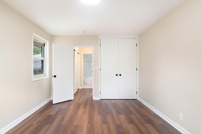 unfurnished bedroom featuring a closet and dark hardwood / wood-style floors