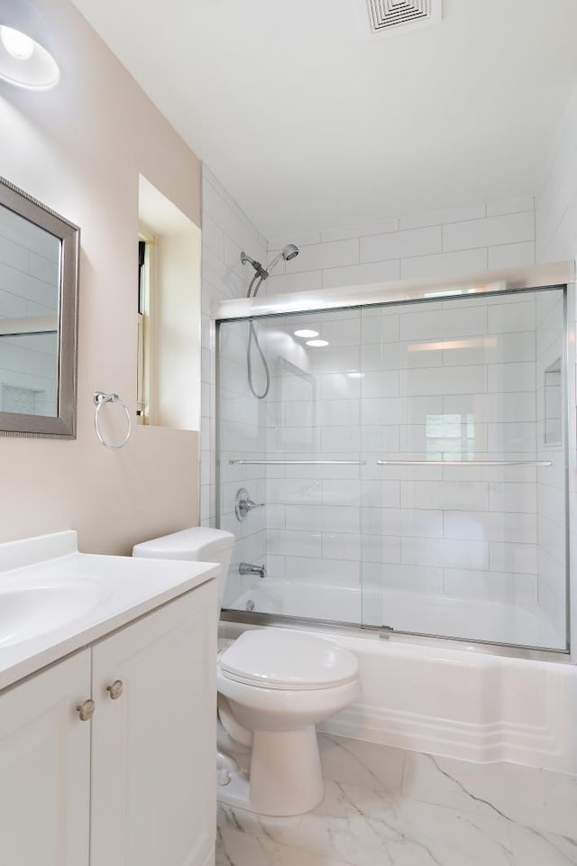 full bathroom featuring shower / bath combination with glass door, vanity, and toilet