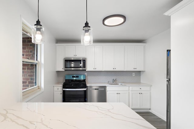 kitchen with white cabinets, decorative light fixtures, stainless steel appliances, and light stone countertops