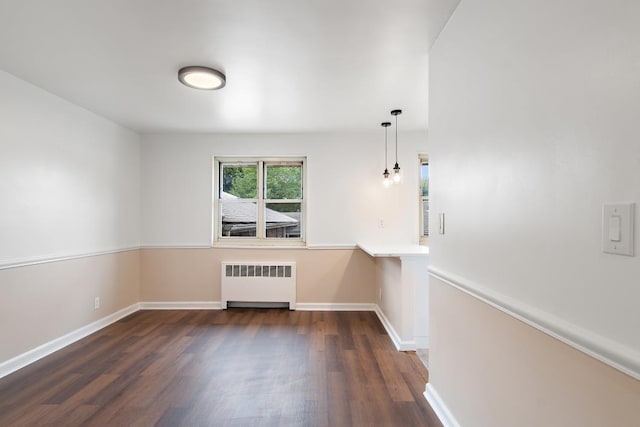 empty room with radiator and dark hardwood / wood-style floors