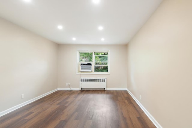 empty room featuring dark hardwood / wood-style flooring, radiator heating unit, and cooling unit