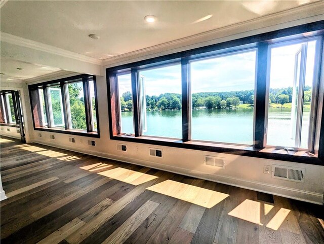 unfurnished room with a wealth of natural light, dark wood-type flooring, and ornamental molding