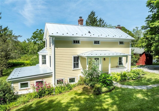 back of house featuring a lawn and covered porch