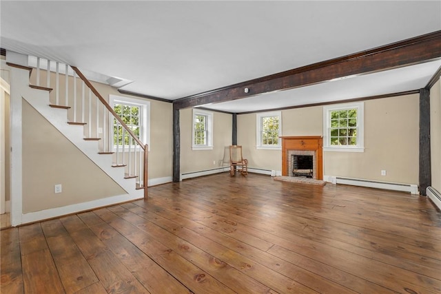 unfurnished living room featuring hardwood / wood-style flooring, a healthy amount of sunlight, a brick fireplace, and a baseboard radiator