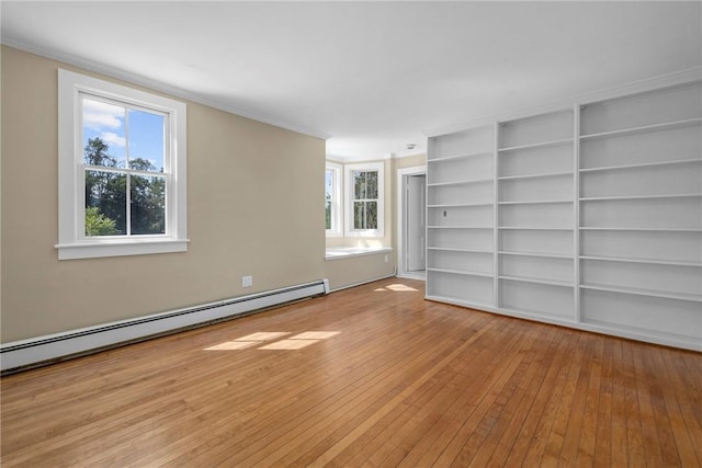 empty room with light hardwood / wood-style flooring and a baseboard heating unit