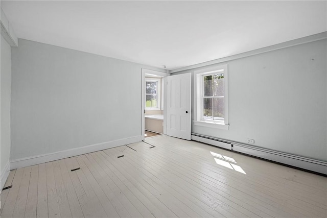 empty room with light hardwood / wood-style flooring and a baseboard radiator