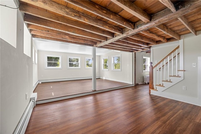 basement with baseboard heating, radiator, wooden ceiling, and a healthy amount of sunlight