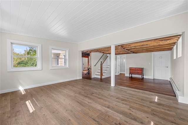 basement with crown molding, wooden ceiling, a baseboard radiator, and hardwood / wood-style flooring