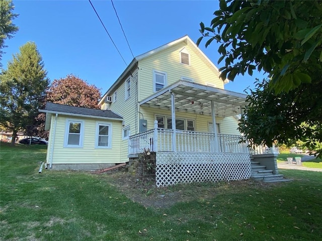 back of house with a lawn and covered porch