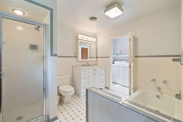 full bathroom featuring vanity, toilet, plus walk in shower, and washing machine and clothes dryer