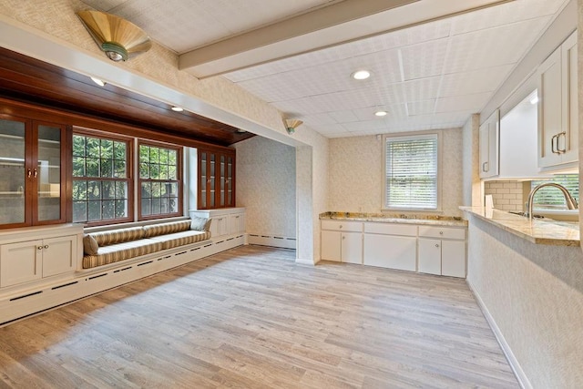 kitchen featuring white cabinets, plenty of natural light, light hardwood / wood-style floors, and sink