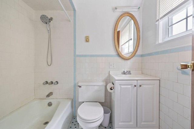 full bathroom with vanity, tiled shower / bath combo, tile walls, tile patterned flooring, and toilet