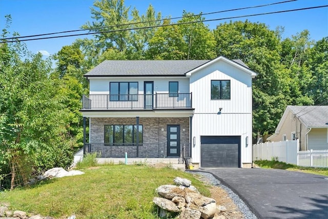 view of front of home with a garage, a balcony, and a front lawn