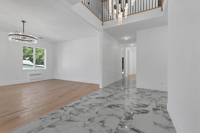 3 Forshee St, Monroe, NY 10950 - unfurnished living room featuring a chandelier, radiator, marble look tiles, and a towering ceiling