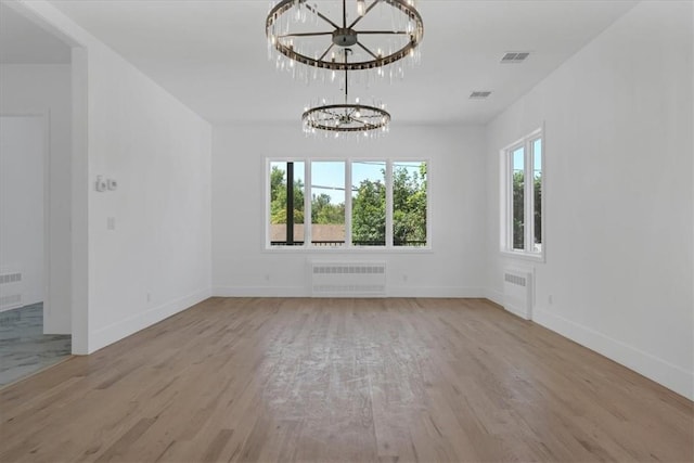 interior space with radiator heating unit, light hardwood / wood-style flooring, and a chandelier