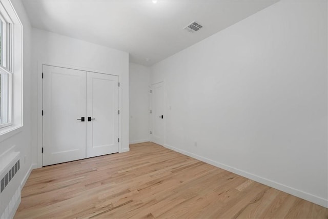 3 Forshee St, Monroe, NY 10950 - unfurnished bedroom with radiator heating unit, light wood-style floors, and a closet