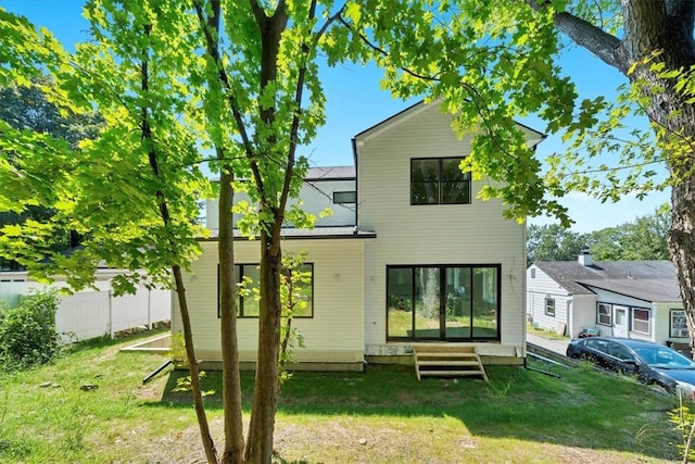 rear view of house featuring a yard