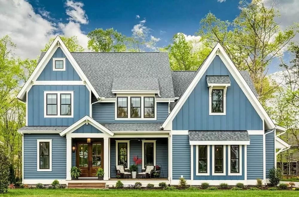 rear view of property featuring a lawn, a porch, and french doors