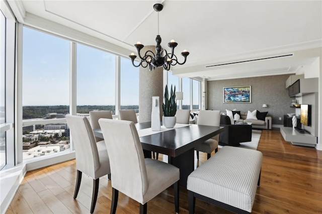 dining space with hardwood / wood-style floors, expansive windows, and a chandelier