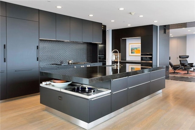 1 Renaissance Sq Unit Ph40A, White Plains, NY 10601 - kitchen with modern cabinets, light wood-type flooring, dark countertops, backsplash, and recessed lighting