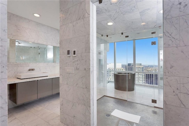 1 Renaissance Sq Unit Ph40A, White Plains, NY 10601 - bathroom featuring vanity, expansive windows, tile walls, walk in shower, and recessed lighting