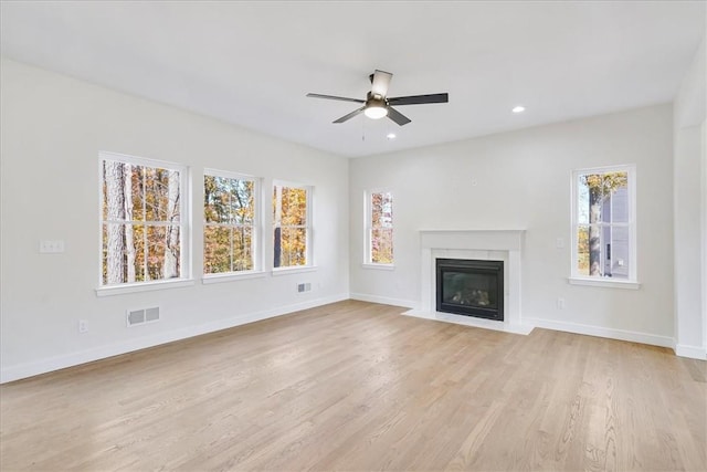 unfurnished living room with a wealth of natural light, light hardwood / wood-style flooring, and ceiling fan