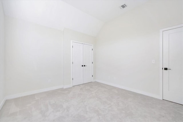 carpeted empty room with lofted ceiling