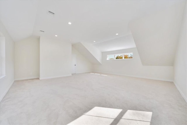 additional living space with light colored carpet and vaulted ceiling