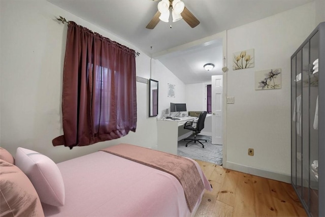 bedroom with light wood-type flooring, vaulted ceiling, and ceiling fan