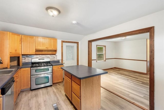 kitchen with sink, a kitchen island, tasteful backsplash, light hardwood / wood-style floors, and stainless steel appliances