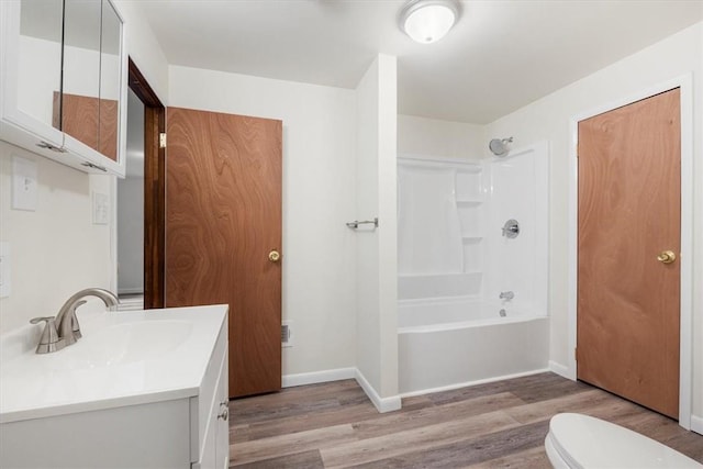 full bathroom featuring hardwood / wood-style floors, vanity,  shower combination, and toilet